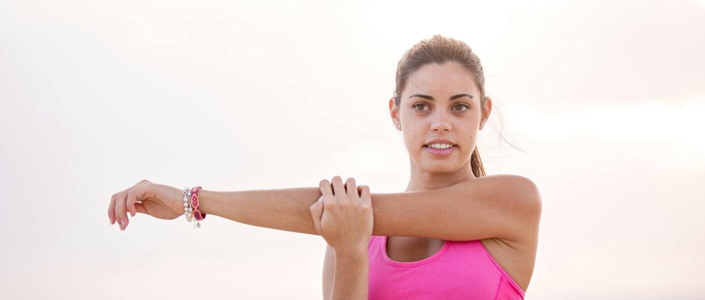 Sporter voert een staande hamstring stretch uit om zijn flexibiliteit te verbeteren.